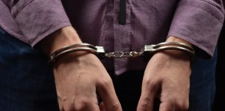 Person wearing handcuffs on their wrists