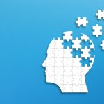 Silhouette head made of puzzle pieces on blue background