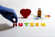 Gloved hand placing autism letters near medical items