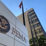 FEMA building with flags and blue sky backdrop