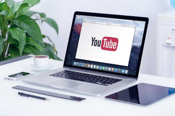293731787 Laptop displaying YouTube, with coffee and stationery nearby