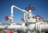 Industrial pipeline with red valves against a clear blue sky