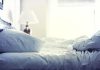 A cozy unmade bed with soft pillows and bedding in a well lit room