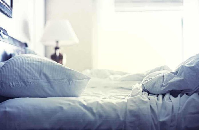 shutterstock_197128130.jpg A cozy unmade bed with soft pillows and bedding in a well lit room