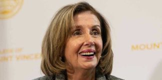 Smiling woman in plaid blazer with pearl necklace.