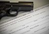 A handgun placed on top of a concealed carry license application form