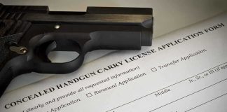 A handgun placed on top of a concealed carry license application form
