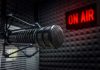 Radio microphone in studio with On Air sign.