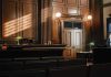 Empty courtroom with judges bench and wooden decor.