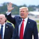 Trump Pardons Billionaire Bro: Hidden Political Agenda? Man in suit waving while another man stands nearby.