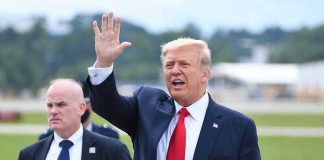 Trump Pardons Billionaire Bro: Hidden Political Agenda? Man in suit waving while another man stands nearby.