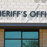 Sheriff JAILED – Deputies Arrest Him! Sheriffs Office sign on brick building faade.