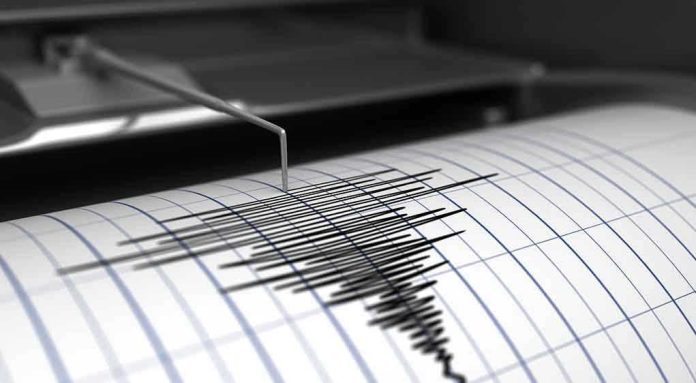 415252909 Seismograph needle recording earthquake activity on paper.