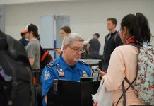 $10,000 Paydays Stun TSA Veterans TSA agent checks passengers documents at airport security.
