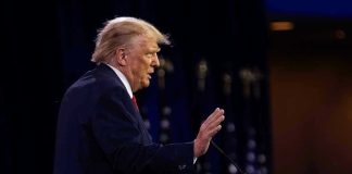 Comey, James Indictment Implodes – Trump VOWS Revenge Person speaking at a podium with hand raised