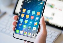 A person holding a smartphone displaying various mobile applications