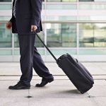 Airport Lounge PANIC—Tiny Gadget Ignites Chaos A businessman in a suit walking with a suitcase at an airport