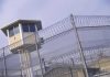 Celeb ICON FREED From Prison – Released Back Into Society Guard tower behind barbed wire fence in a prison.