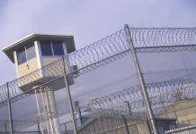 Celeb ICON FREED From Prison – Released Back Into Society Guard tower behind barbed wire fence in a prison.