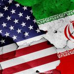 Iran President Declares TOTAL WAR on America Cracked American and Iranian flags on a wall.
