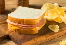 Ham and cheese sandwich with potato chips.