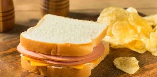 Ham and cheese sandwich with potato chips.