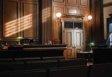 Teacher Sobs in Court–35K Sick Texts Exposed! Empty courtroom with judges bench and wooden decor.