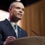 Bongino’s FBI Polygraph Scandal: What’s Really Happening? A man in a suit speaking at a podium during a conference