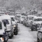Airport Travel Nightmare: Families Sleep on Floors Traffic jam with cars covered in heavy snow during a snowstorm