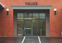 TWERKING Cop Gropes Colleagues – FIRED! Entrance of a modern police station with brick facade