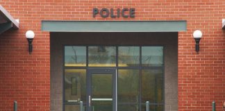 TWERKING Cop Gropes Colleagues – FIRED! Entrance of a modern police station with brick facade