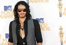 A man with long hair and sunglasses posing at the MTV Movie Awards