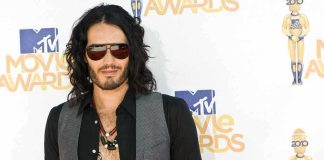 A man with long hair and sunglasses posing at the MTV Movie Awards