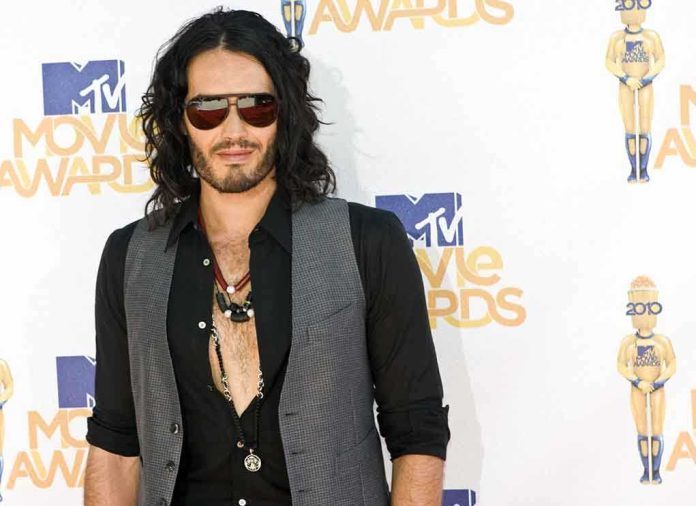 A man with long hair and sunglasses posing at the MTV Movie Awards