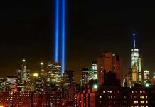 New York City skyline at night with memorial lights.