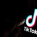 Casey Anthony RETURNS – Latest Stunt Sparks Outrage Finger pointing at TikTok logo on a screen.