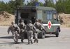 Soldiers running towards a medical vehicle during a military operation