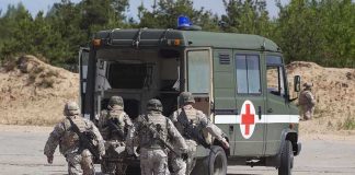 Soldiers running towards a medical vehicle during a military operation
