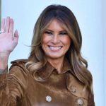 Box Office Shock: “Melania” STUNS! Person smiling and waving wearing a brown coat