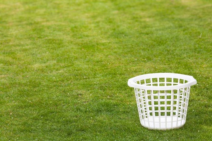 shutterstock_3468242.jpg An empty white laundry basket placed on green grass