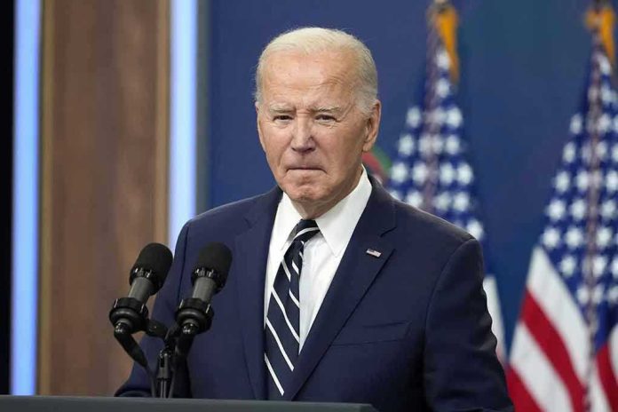 2473357553-1 Man in suit speaking at podium with American flags.