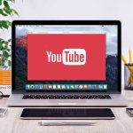 Creators vs. YouTube: Secret AI Changes EXPOSED YouTube logo on a laptop screen on desk.