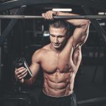 Muscular man in gym holding a shaker bottle