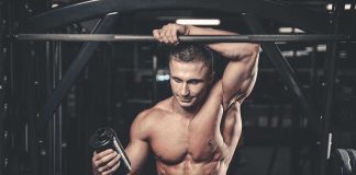 Muscular man in gym holding a shaker bottle