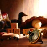 Parents Warned: Viral Toy Trend Nearly Blinds Kids A wooden spinning top surrounded by vintage toys and colorful blocks