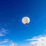 Retired Admiral Claims ALIEN Control! A white balloon floating in a clear blue sky with scattered clouds