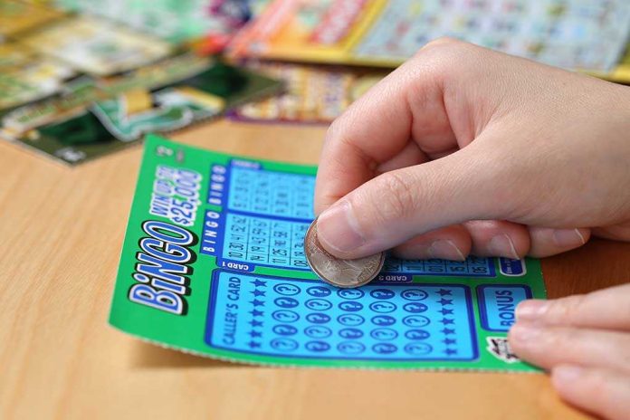 shutterstock_203186986 A person scratching off a bingo lottery ticket with a coin
