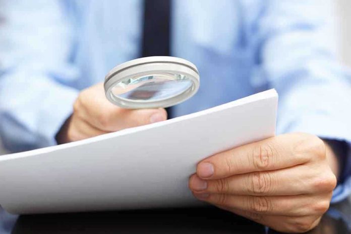 A person using a magnifying glass to examine a document closely