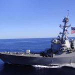 Trump’s Ultimatum Shocks Tehran A naval destroyer sailing in the ocean with an American flag