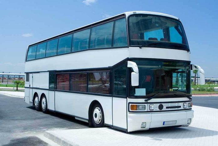 shutterstock_15012409-1 A white double-decker bus parked in an urban area under a clear blue sky